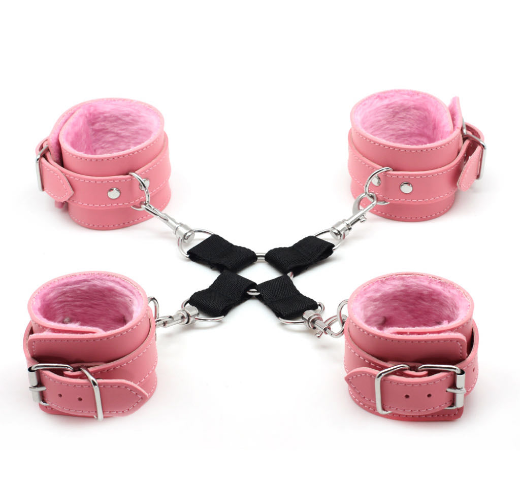 a set of four pink bondage cuffs with black hogtie