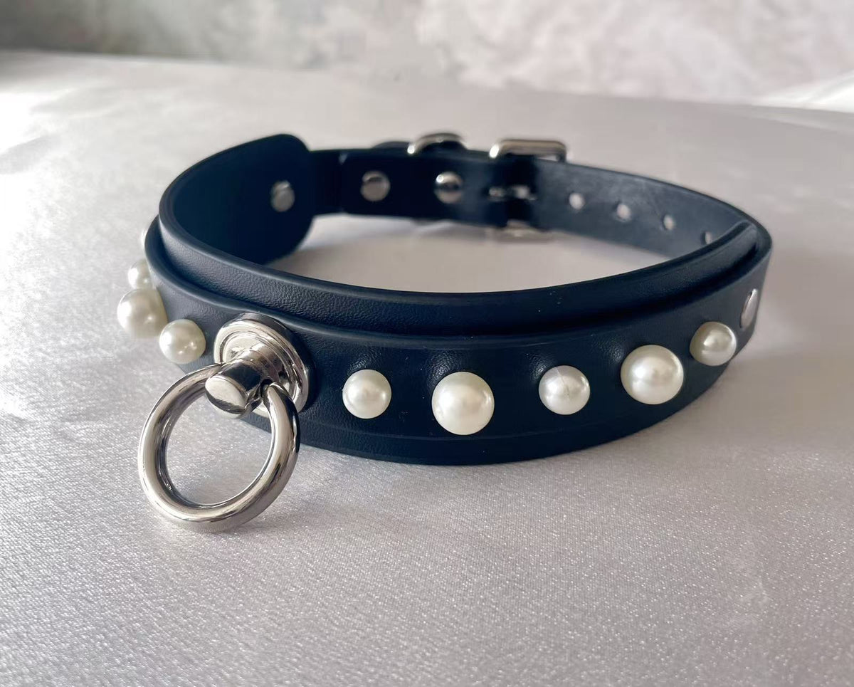 black faux leather collar studded with white pearls and central silver o ring