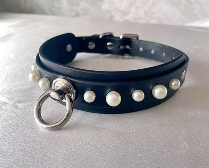 black faux leather collar studded with white pearls and central silver o ring