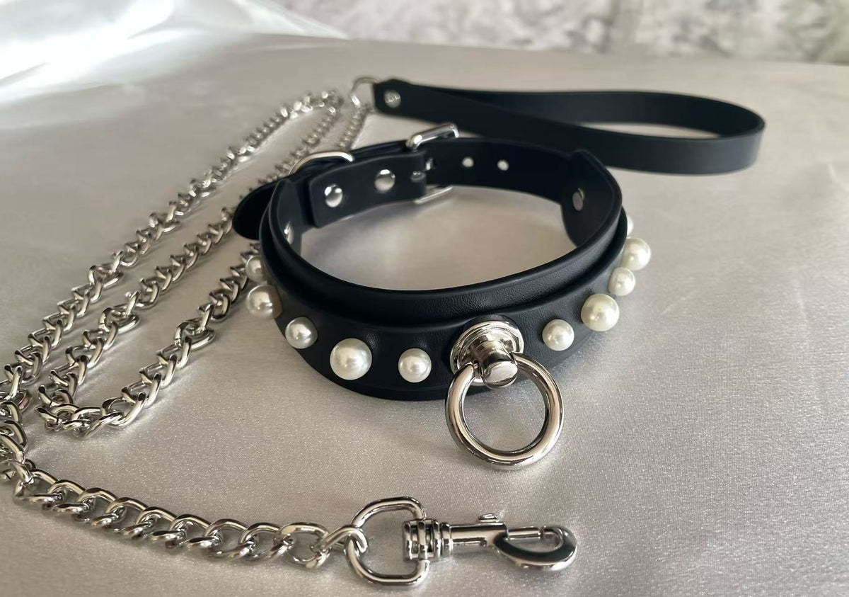 black faux leather collar studded with white pearls and central silver o ring