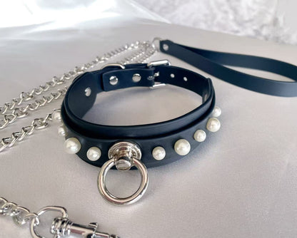 black faux leather collar studded with white pearls and central silver o ring