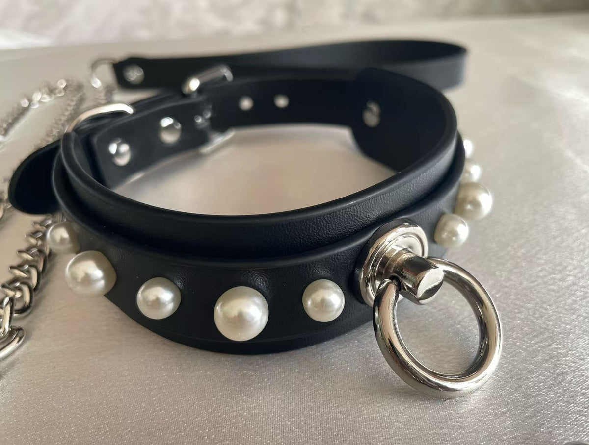 black faux leather collar studded with white pearls and central silver o ring