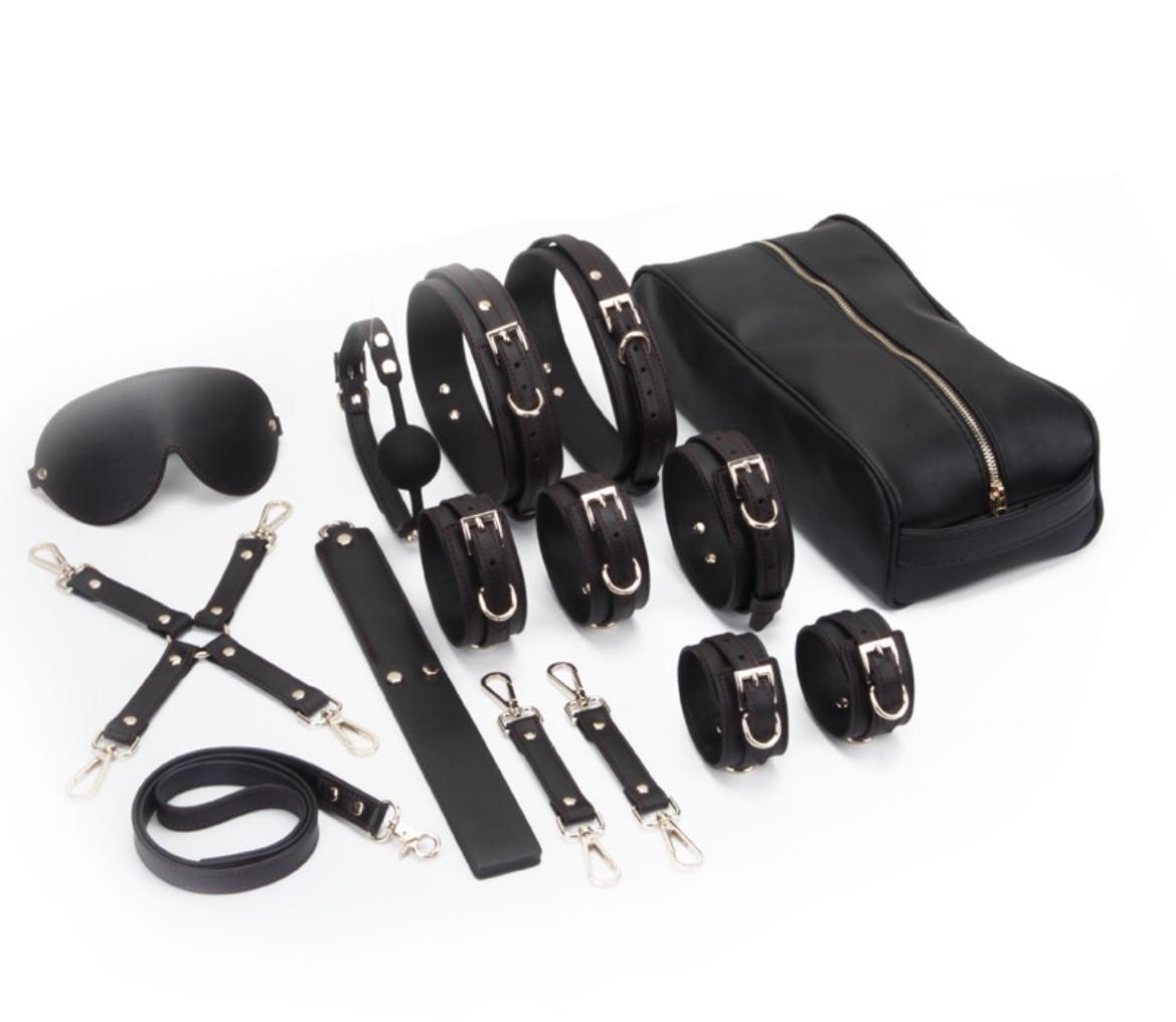 a black bondage kit with leather handcuffs ankle cuffs thigh cuff collar and leash paddle blindfold ball gag hogtie