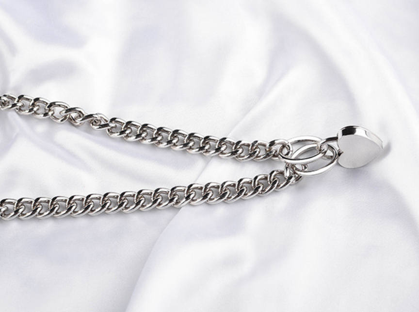 A pair of black bondage handcuffs with a chain link connection